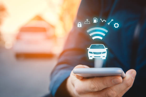 Intelligent car app on smart phone concept Intelligent car app on smart phone concept, intelligent vehicle and smart cars concept. Person with smart phone on street, car in background and wireless communication with car. car technology stock pictures, royalty-free photos & images
