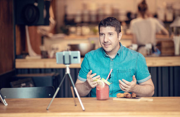 Food blogger man creating content in a small restaurant stock photo