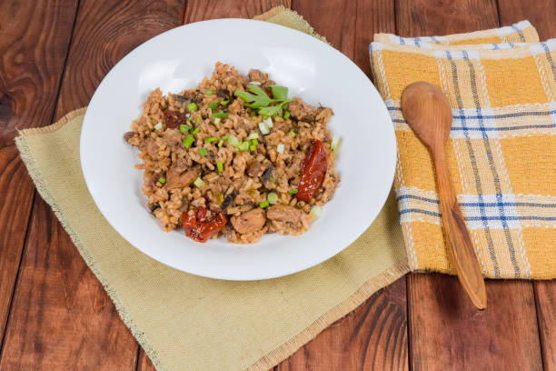 istock Paella with meat on dish and spoon on rustic table 1226913829