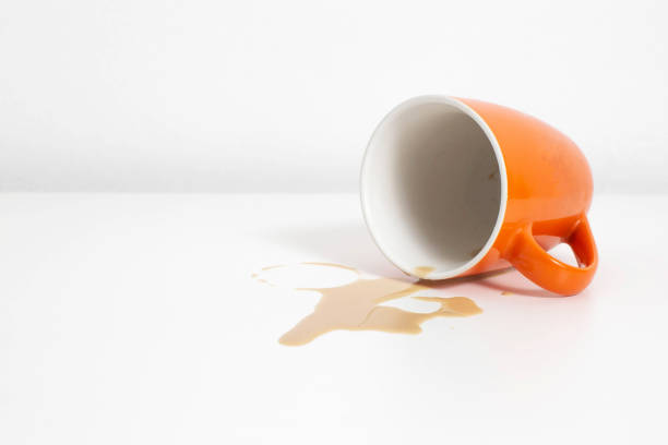 istock Spilled coffee from an orange cup on a white table in the office, copy space 1226914293