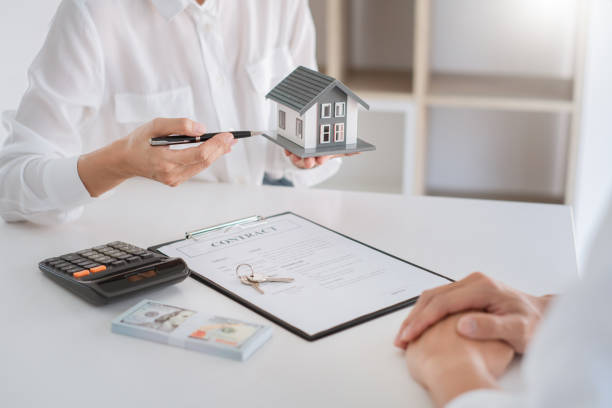 istock Woman Holding House Model On Table 1226916229