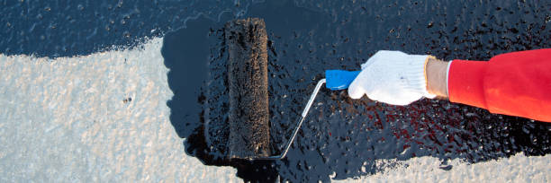istock Worker applies bitumen mastic on the foundation 1226917282