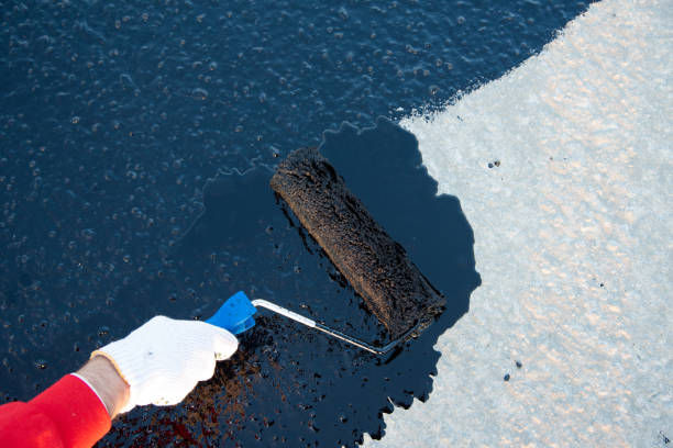 Worker applies bitumen mastic on the foundation