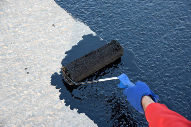 istock Worker applies bitumen mastic on the foundation 1226917319