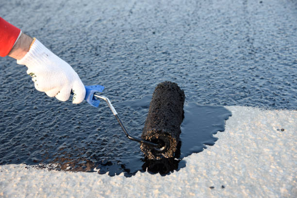 Worker applies bitumen mastic on the foundation