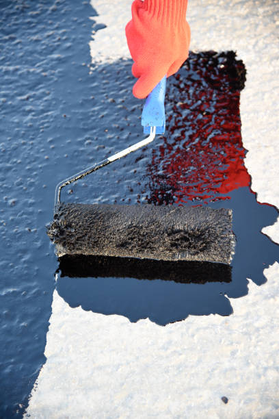 istock Worker applies bitumen mastic on the foundation 1226917848