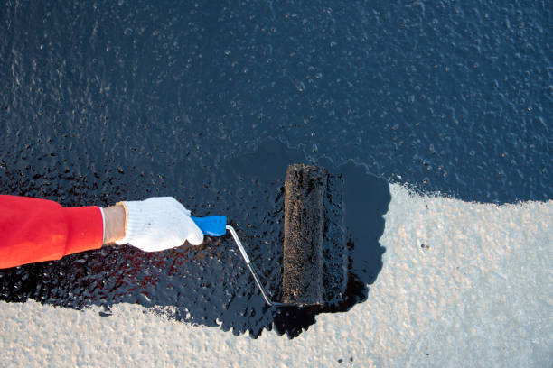 istock Worker applies bitumen mastic on the foundation 1226917874