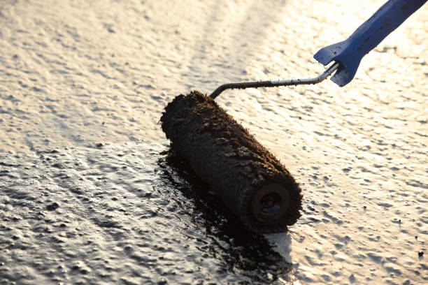 istock Worker applies bitumen mastic on the foundation 1226917964