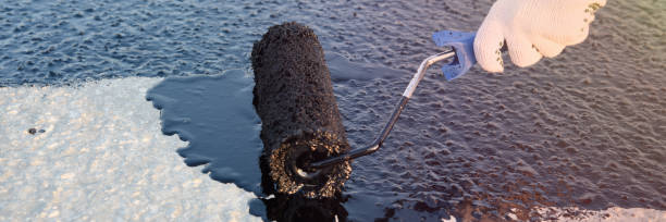 istock Worker applies bitumen mastic on the foundation 1226918046
