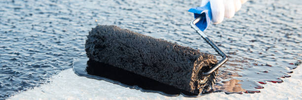 istock Worker applies bitumen mastic on the foundation 1226918055