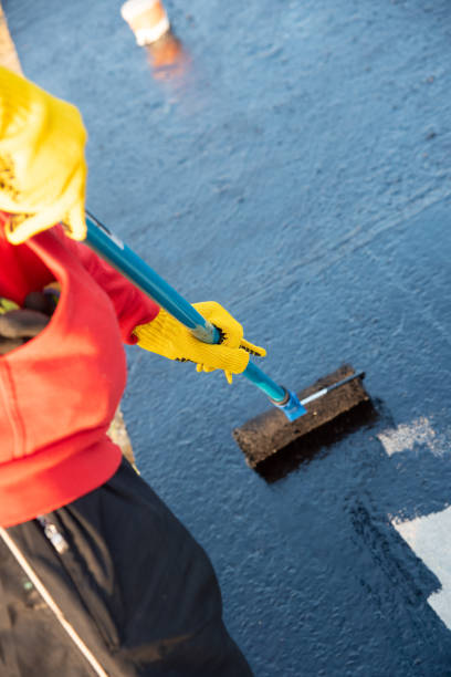 Worker applies bitumen mastic on the foundation stock photo