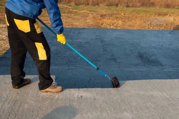 istock Worker applies bitumen mastic on the foundation 1226918219