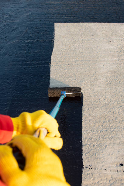 istock Worker applies bitumen mastic on the foundation 1226918278