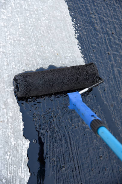 istock Worker applies bitumen mastic on the foundation 1226918306