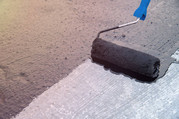 istock Worker applies bitumen mastic on the foundation 1226918340