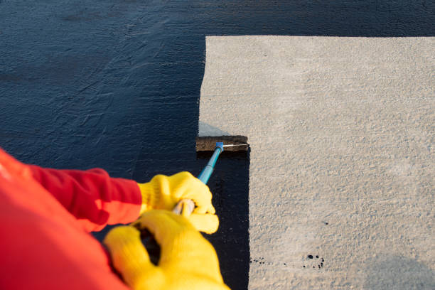istock Worker applies bitumen mastic on the foundation 1226918407