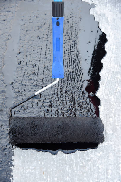 istock Worker applies bitumen mastic on the foundation 1226918415