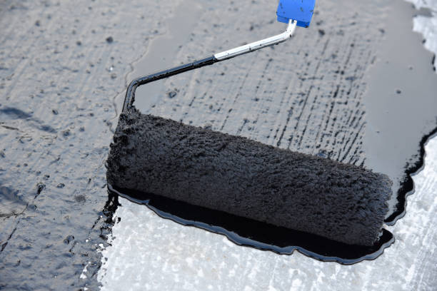 istock Worker applies bitumen mastic on the foundation 1226918421