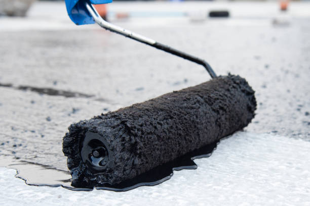 istock Worker applies bitumen mastic on the foundation 1226918432