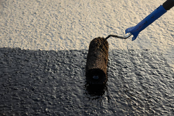 istock Worker applies bitumen mastic on the foundation 1226918448