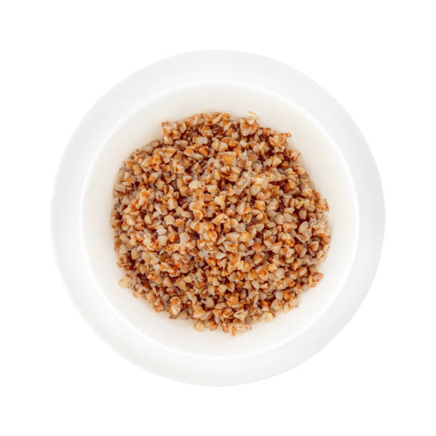 istock Deep white plate on a saucer with boiled buckwheat. Top view. Isolate on a white background. 1226921488