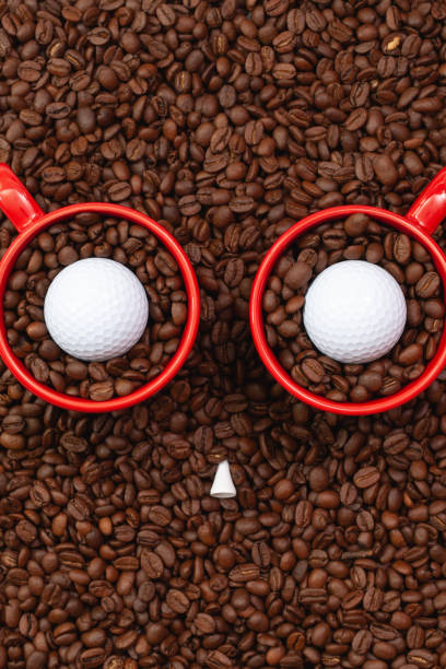 istock Two red cups full of coffee beans and one golf ball. 1226923121