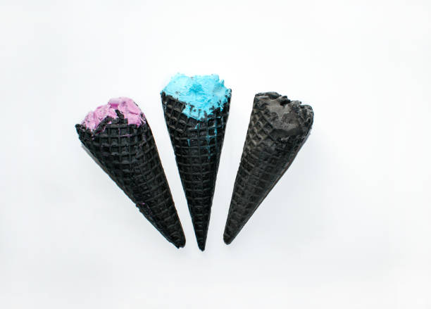 istock Multicolored ice cream in black horn isolated on a white background. Top view three coal ice cream cones with soft dairy balls. 1226924659