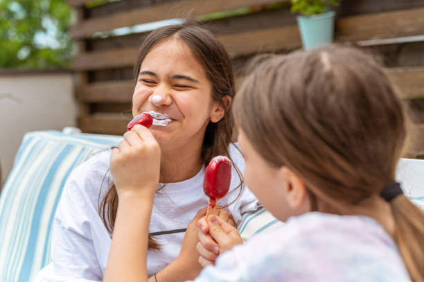istock Two girls having fun with ice cream and using it as a lipstick 1226924774