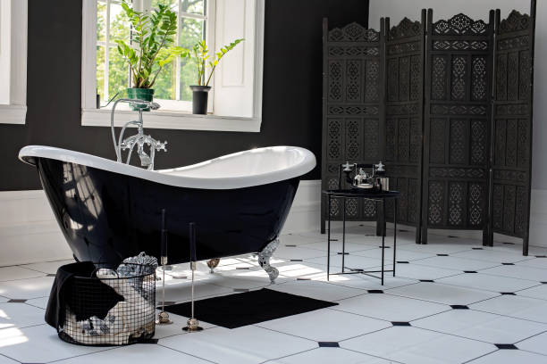 istock Black and white modern bathroom with silver fittings with large sunny windows. Interior design concept. Soft selective focus. 1226924898