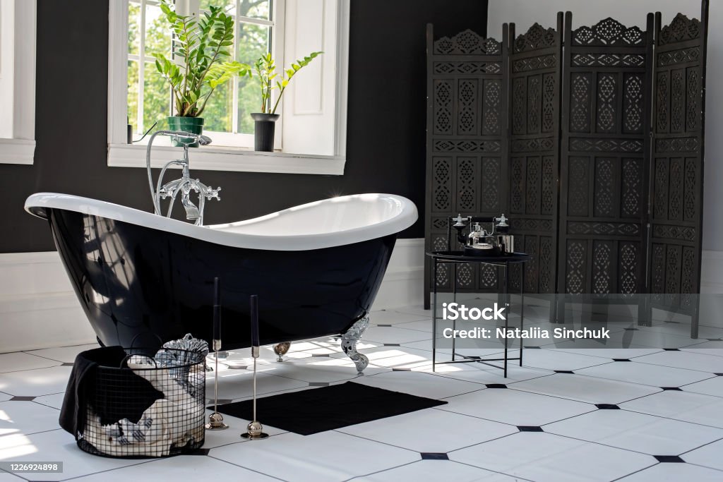 Black and white modern bathroom with silver fittings with large sunny windows. Interior design concept. Soft selective focus. Building Story Stock Photo
