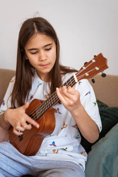 istock Young girl playing ukulele 1226925631
