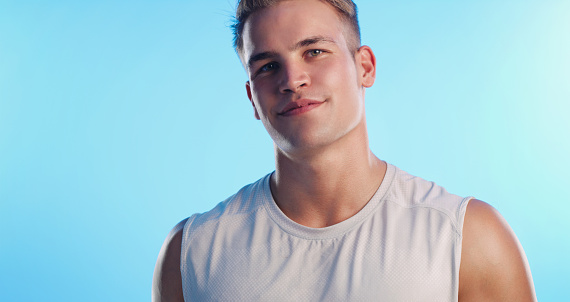 Studio portrait of a handsome young man posing against a blue background