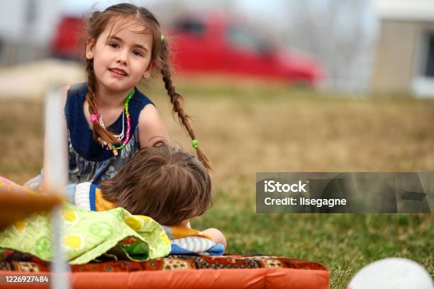 Big Sister Trying To Put Her Little Brother To Sleep Stock Photo - Download Image Now