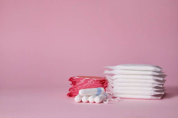 menstrual sanitary cotton pads and tampon stack of menstrual sanitary cotton pads and tampon on pink background. Feminine hygiene products. copy space. sanitary napkin stock pictures, royalty-free photos & images