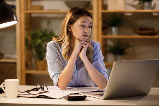 istock Young woman using a laptop and calculator while working from home 1226931198