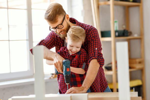 istock Happy kid helping father in carpentry studio 1226935246