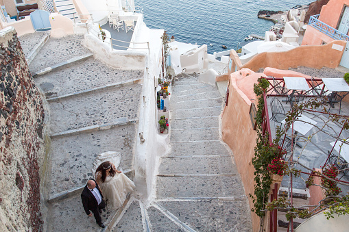 Beautiful young wedding couple posing on stairs of Santorini