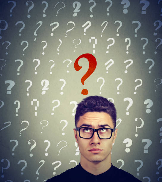 istock Serious business man looking up at a key red question 1226936458