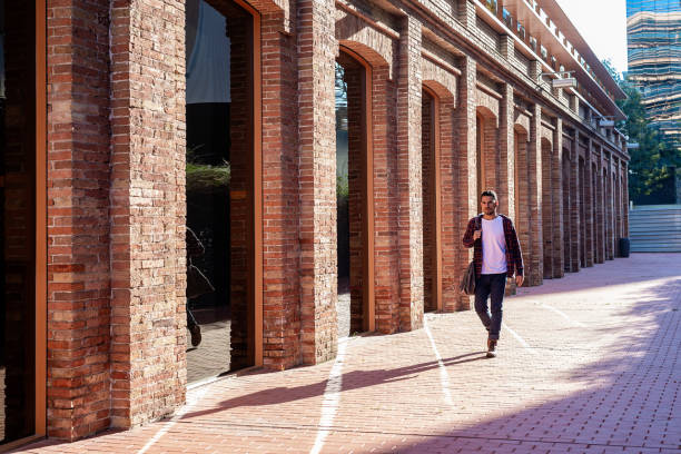 istock Bearded young male holding shoulder bag while walking in a business district 1226938223