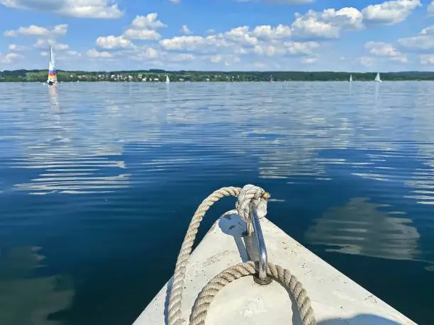 Boating on beautiful lake on blue sky and pleasant green landscape background and lovely reflection on water surface. Sailing and rowing are a popular sport and activity