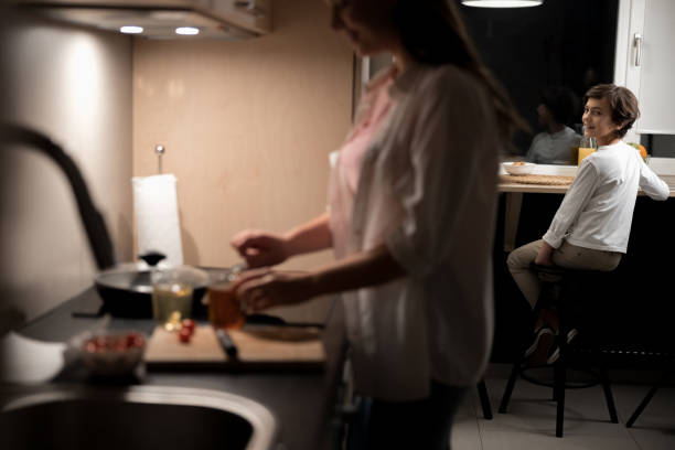 istock Kid at the table looking at his mother 1226938515