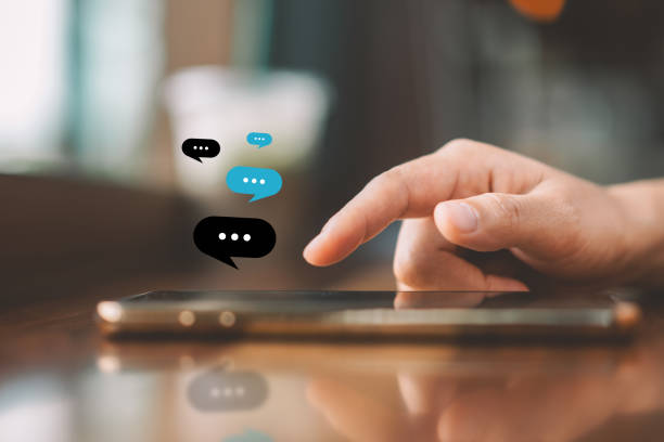 istock Woman hand using smart phone with chat icon graphic at coffee shop abstract background. Technology business and freelance concept. 1226938556