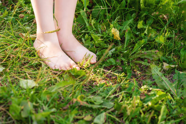 istock Barefoot of child standing on green grass. 1226943123