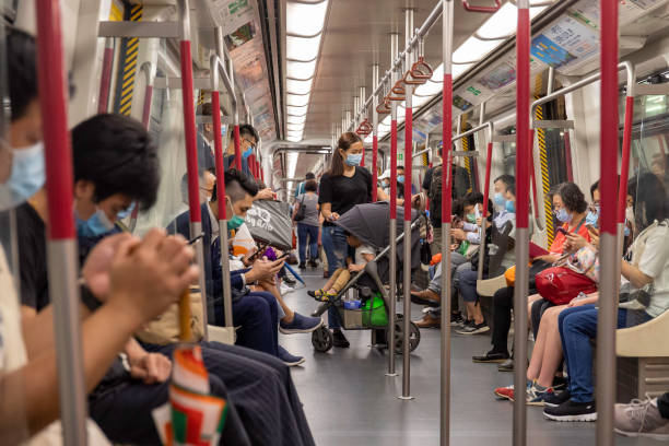 ciudadanos que llevan máscaras faciales en el metro/mtr para prevenir la infección por coronavirus (covid-19) en hong kong - subway train fotografías e imágenes de stock