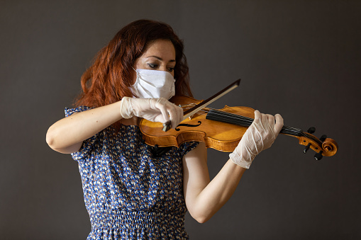 Female musician who plays violin in covid19 outbreak quarantine days.