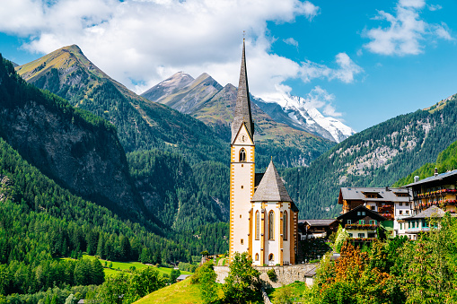 Pfarrkirche - Heiligenblut am Großglockner. Vincent Church, surrounded by Austrian Alps mountains in a sunny day.