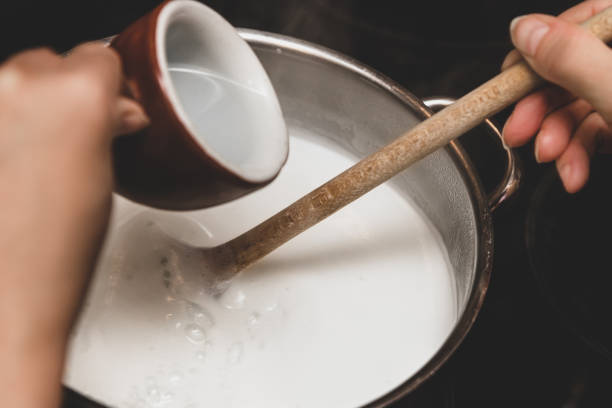 Fresh cheese making step by step, hot milk into a pot, vinegar or lemon juice for clotting and coagulation
