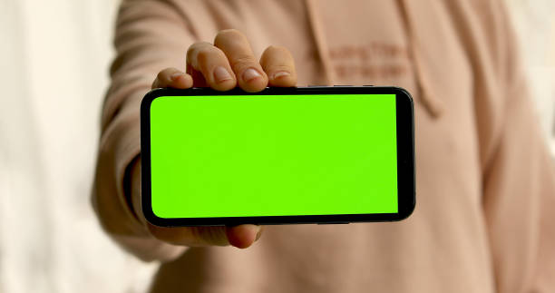 istock Woman shows smartphone with green screen 1226951764