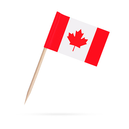 Miniature paper flag Canada. Isolated Canadian toothpick flag pointer on white background. With shadow below