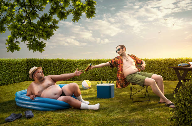 zwei lustige nerds entspannen im hinterhof am sommertag - gartengrill fotos stock-fotos und bilder
